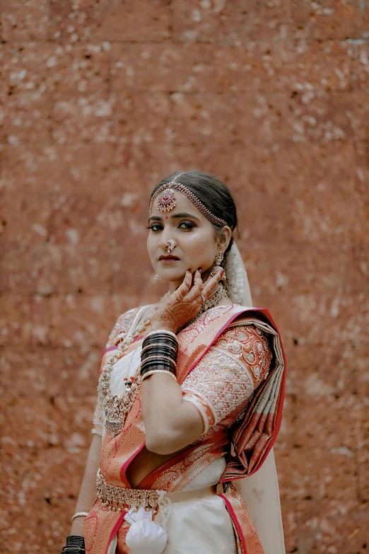 an indian bride standing with her hands on the chin