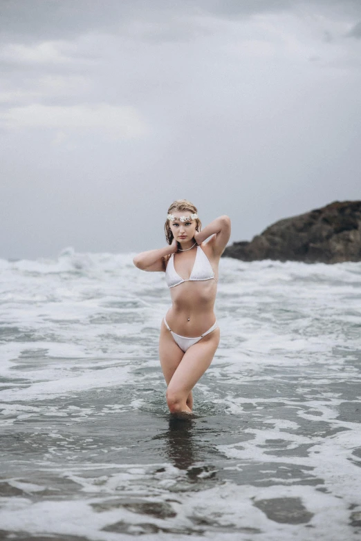 a woman in a white bikini standing in the water