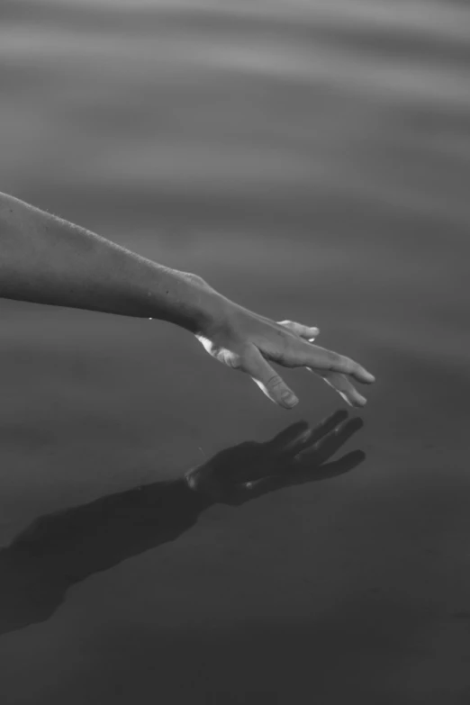 a woman is outstretched over the water with her arm outstretched