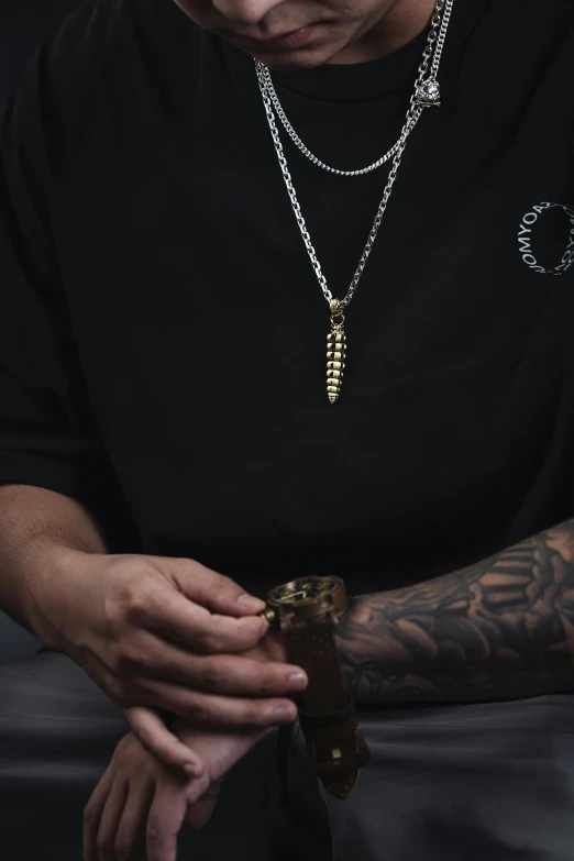 a man with tattoos on holding his hand near some chain