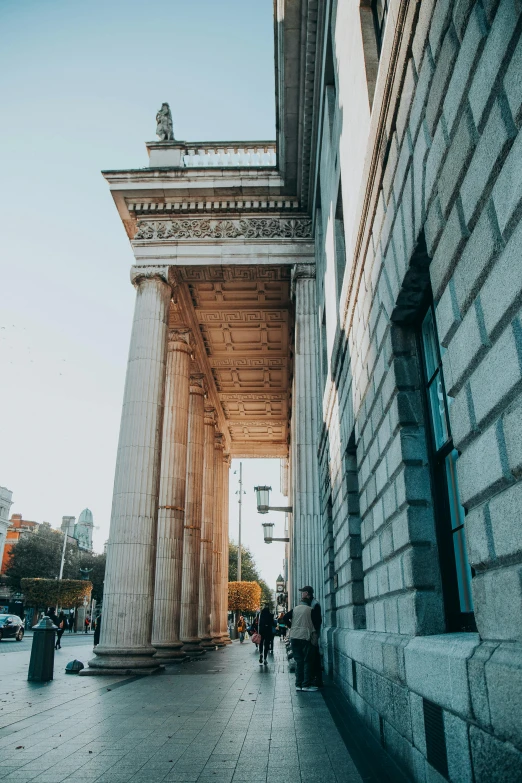 the arch in front of a stone building is flanked by columns