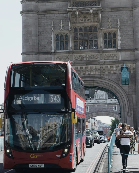 a double decker bus driving through a city gate
