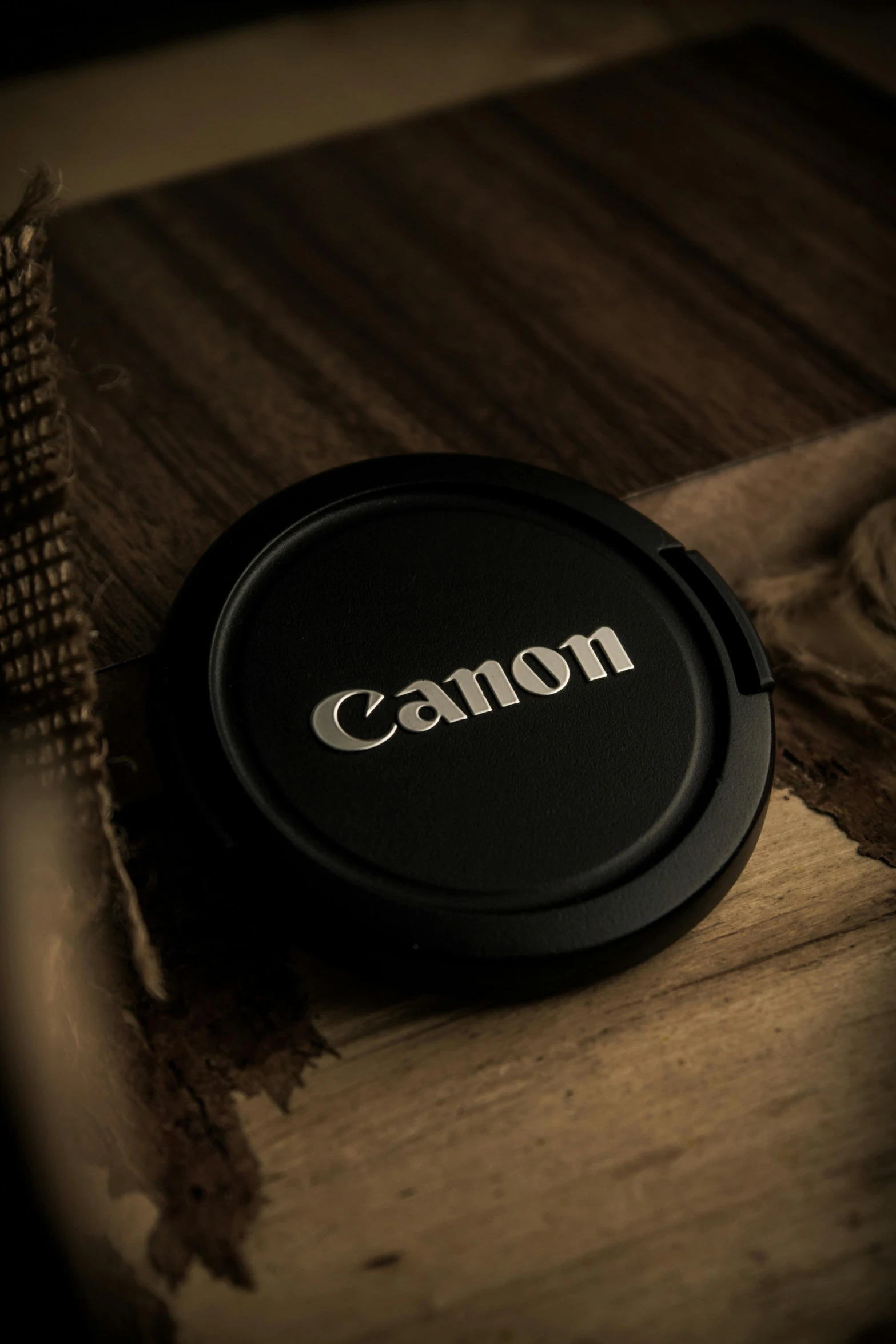 the bottom lid of a canon ds - 70 camera on a wood surface