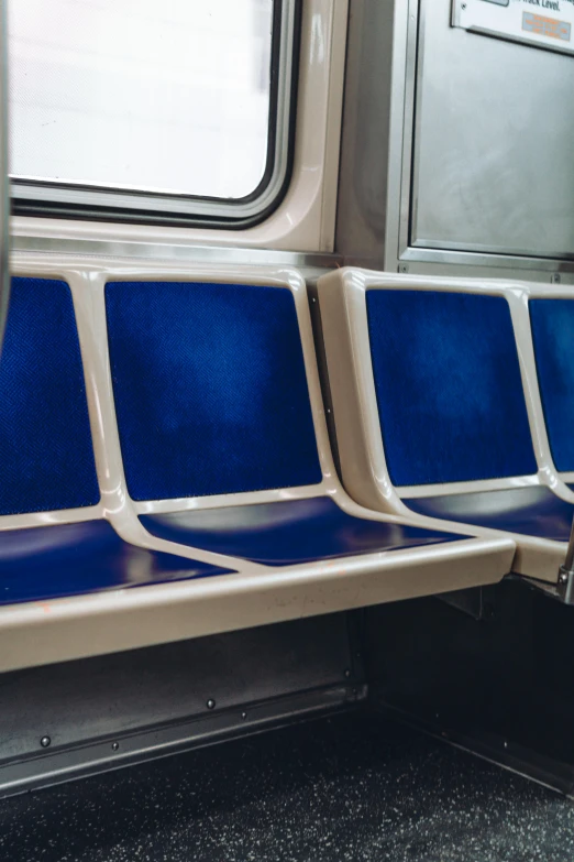 two blue seats that are sitting together on a train