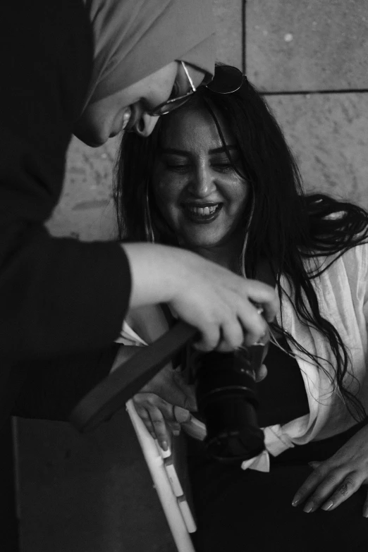 a girl smiling and looking at soing while she combs her hair