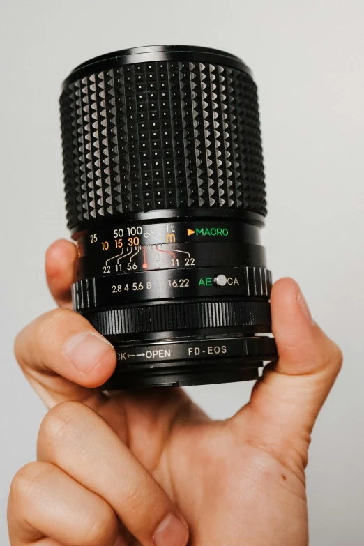 hand holding a lens with its thumb pointed down