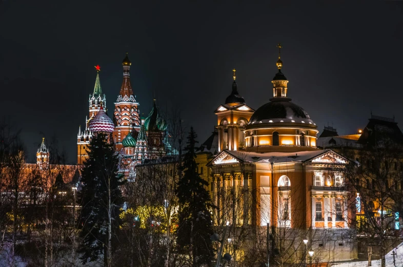 the lights shine brightly on a night time scene with the tall buildings