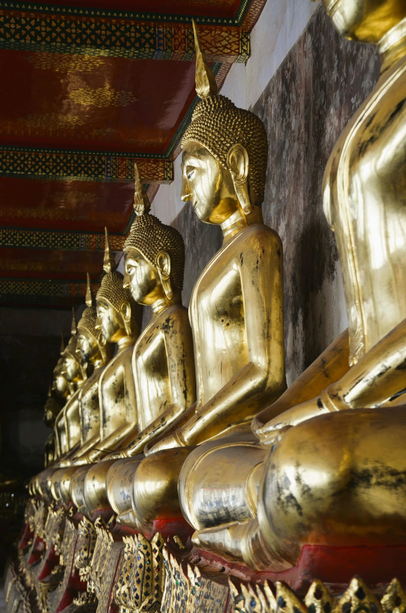 the golden statues line the walls in this asian style temple