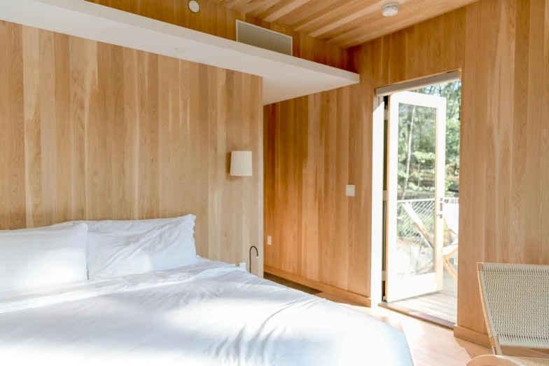 a bedroom with wood walls and wooden ceiling