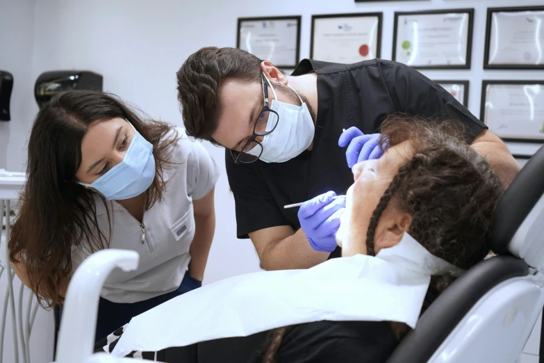 a man getting his teeth checked by a dental team