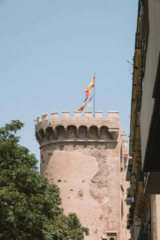 the top of a brick tower with a flag on it