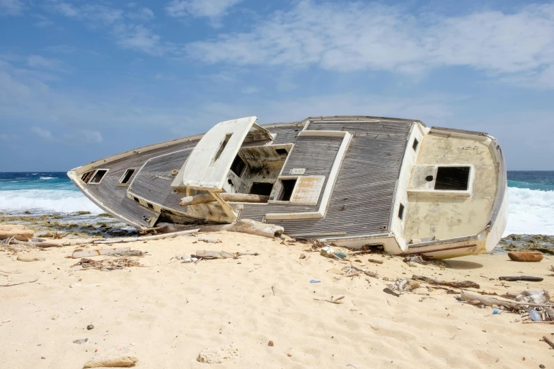 an abandoned, rusted, run down boat in the sand