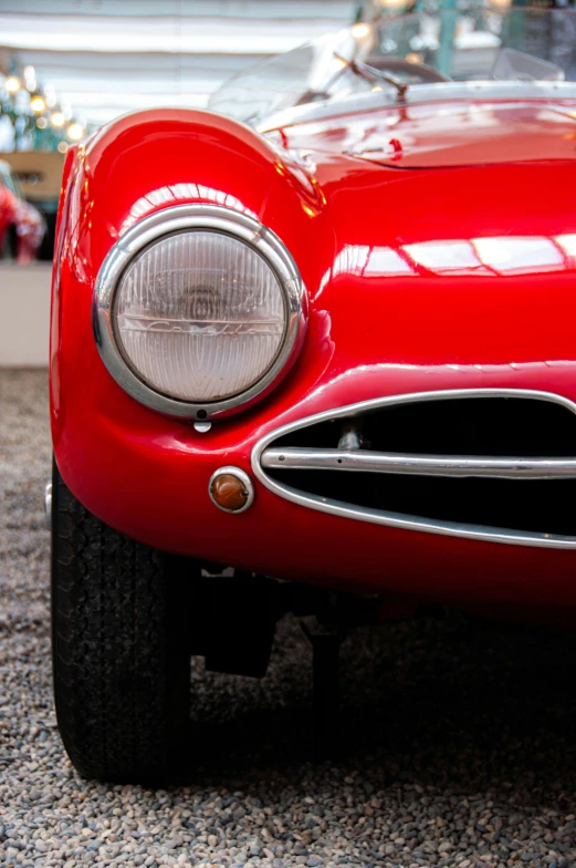 an antique red sports car is in an antique showroom