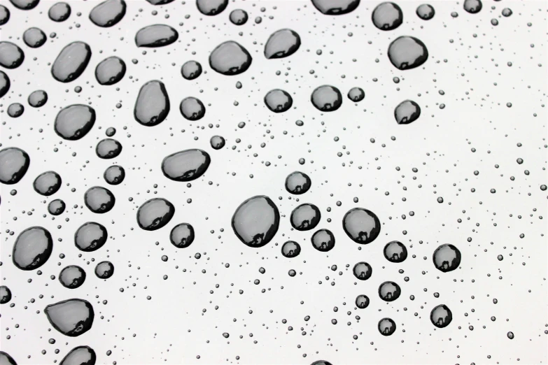 drops of water are on the glass in black and white