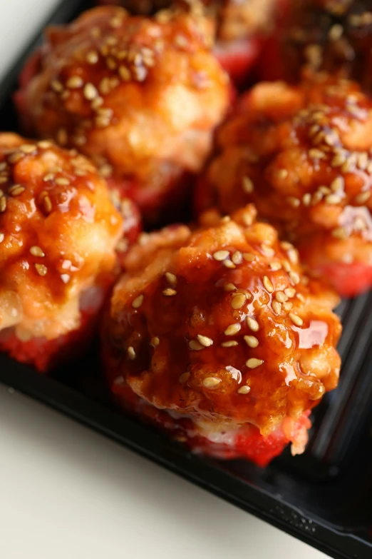 several stuffed meatballs sitting in a black plastic container