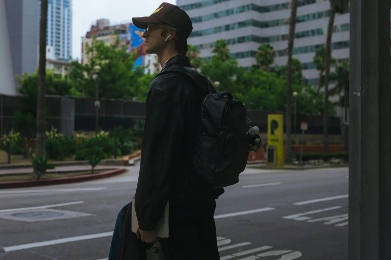 a man is standing on the street with a backpack