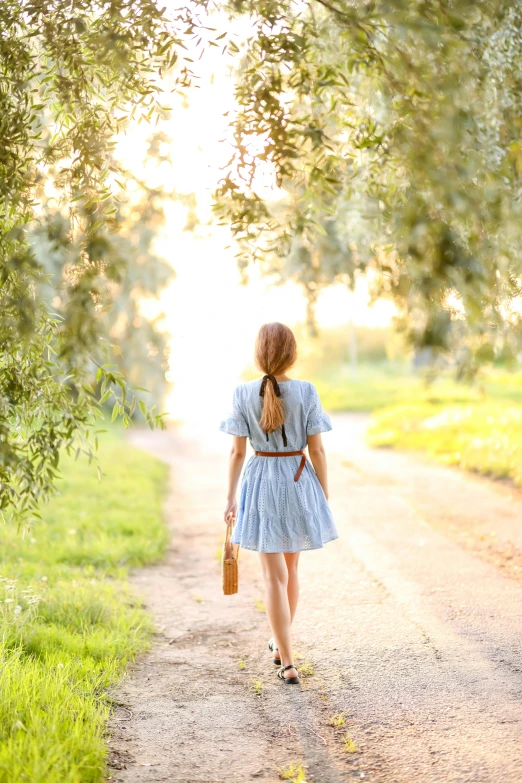 a woman walking down a dirt road