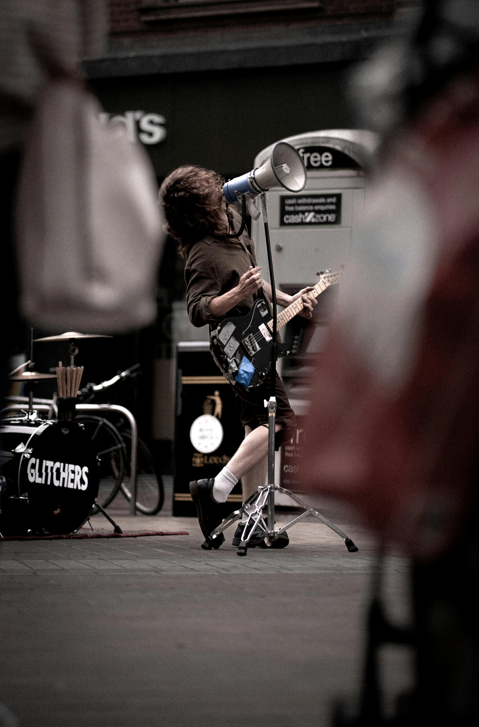 a man playing guitar on stage in front of an audio microphone