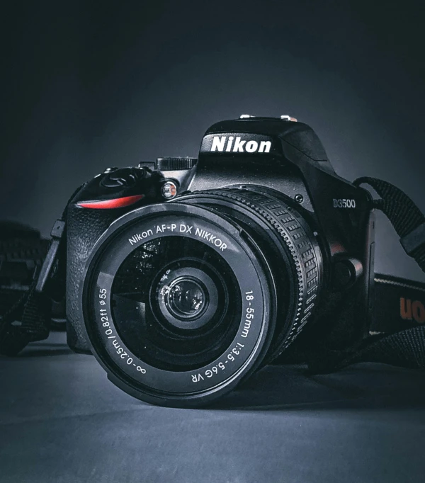 a nikon camera sitting against a dark background