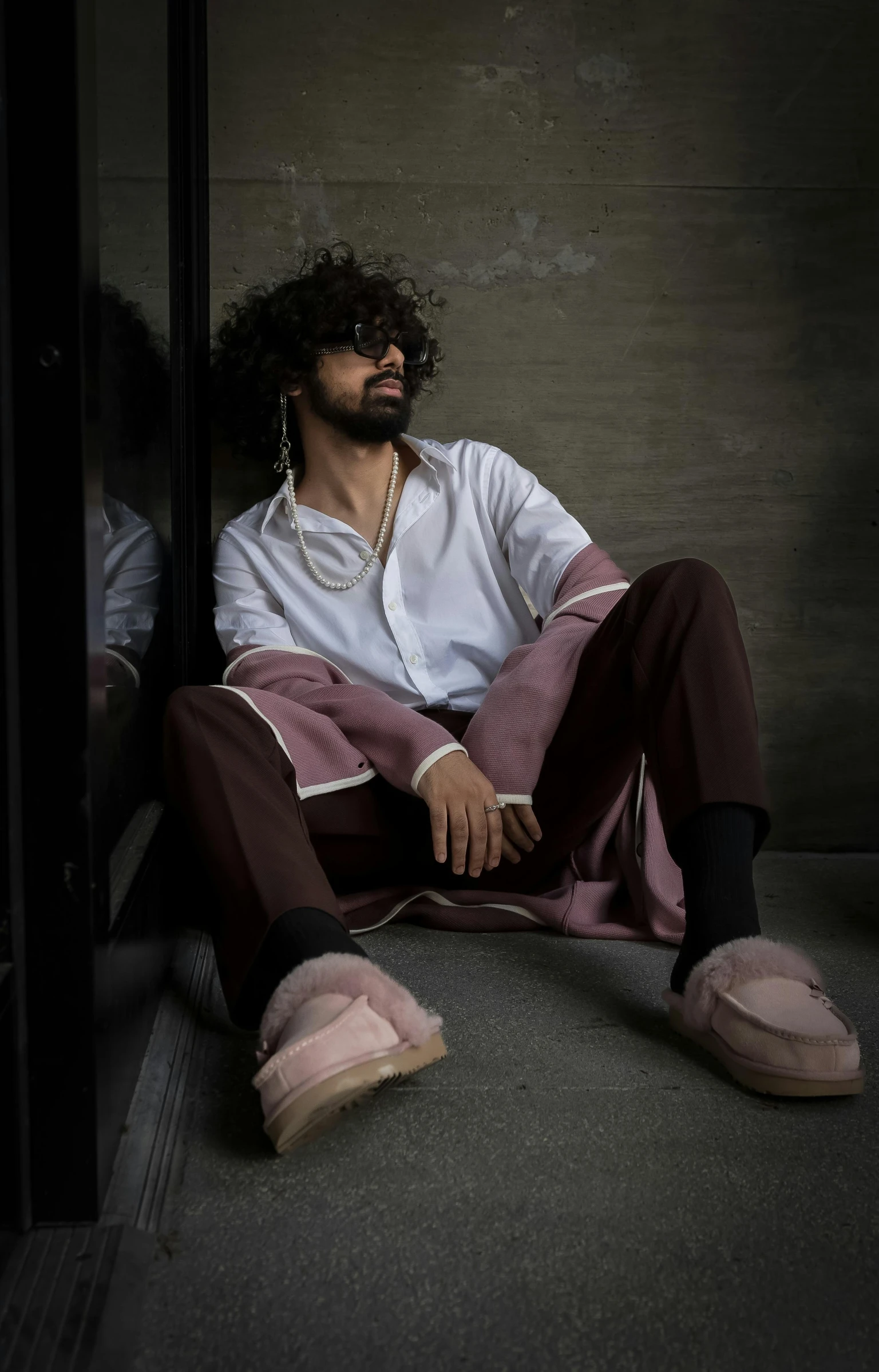 a man sitting in a corner with his shoes on