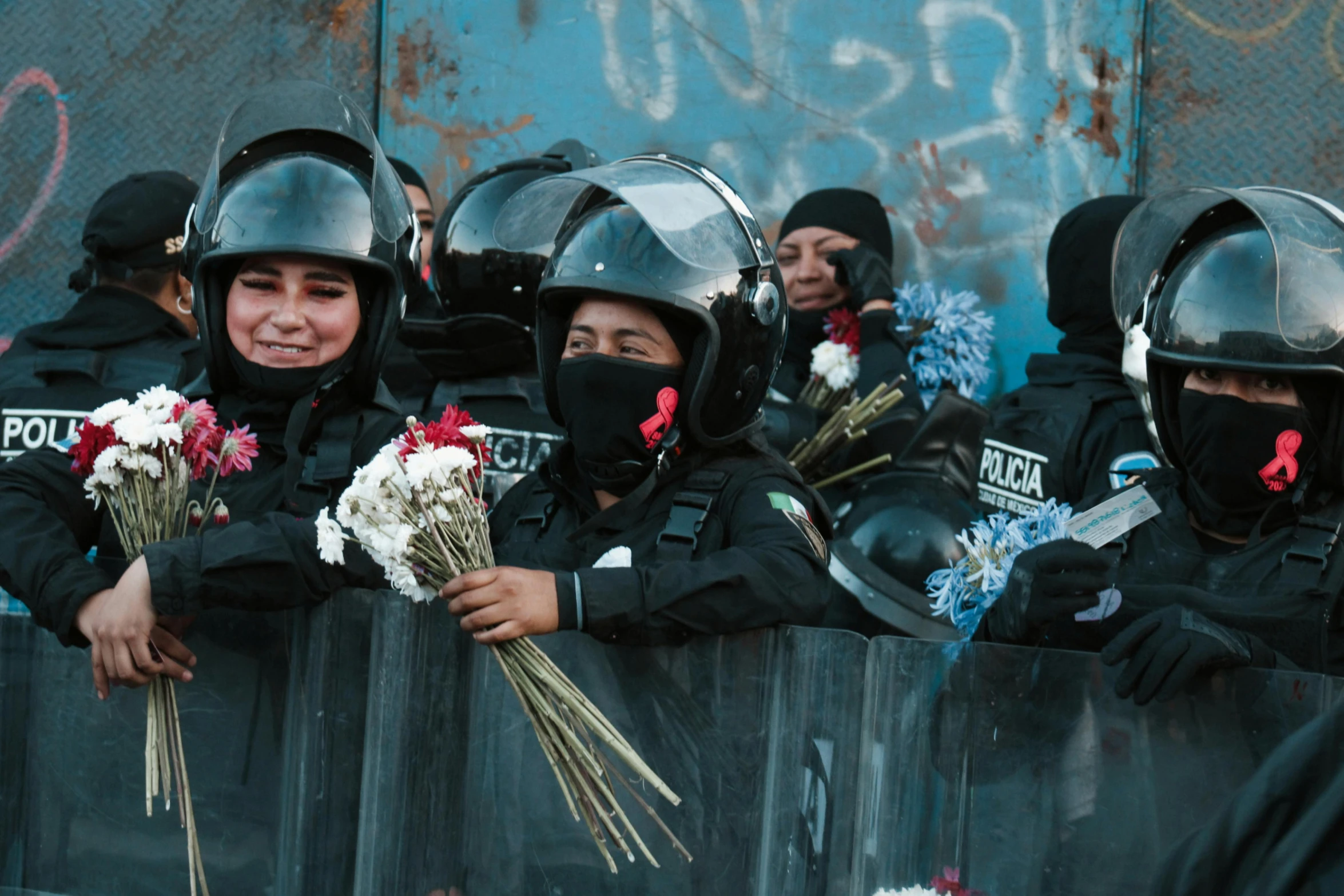 group of girls wearing police uniforms with flowers in their hands