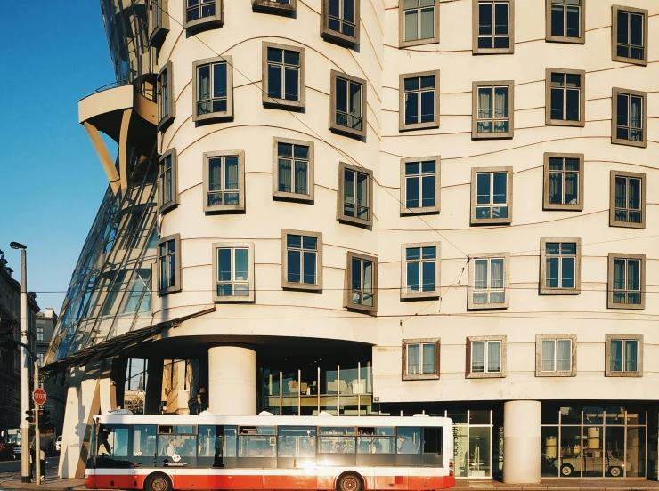 a city bus driving past a tall building