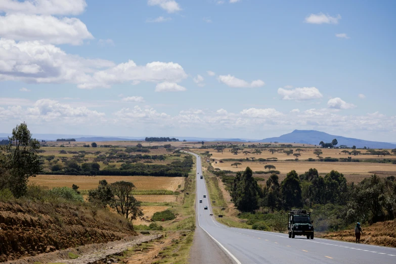 the truck is driving on the highway through the plains