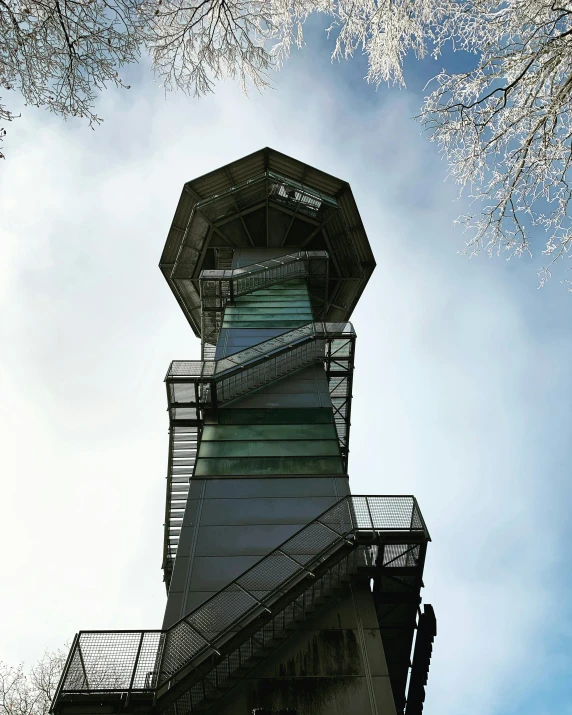 an observation tower rises above a blue sky with a few white clouds