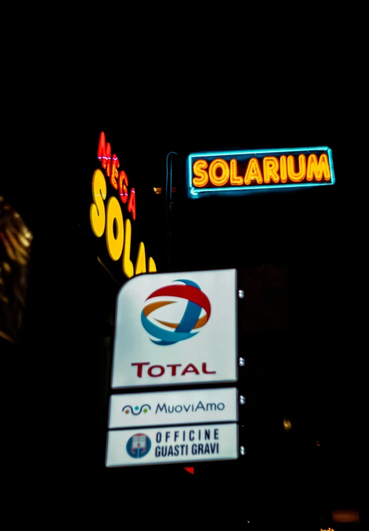 an electric sign and the logos of solarium and total moly afino