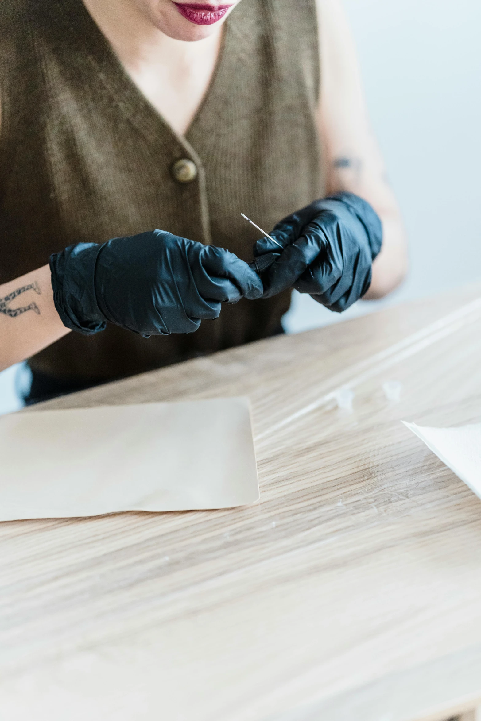 a close up of a person wearing gloves and writing on paper