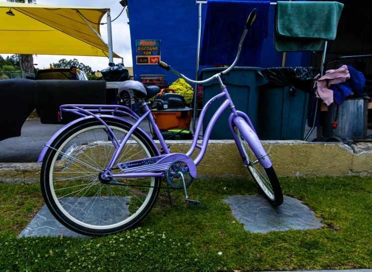 a purple bike is parked next to the side of a wall