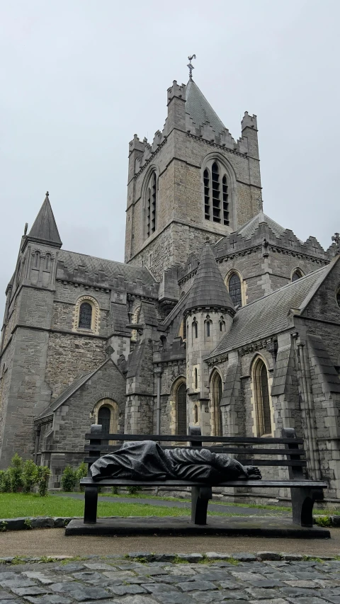 a stone church with a statue on the front lawn