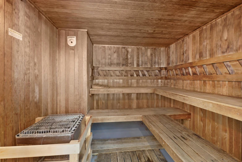 a room containing several wooden benches and a shelf