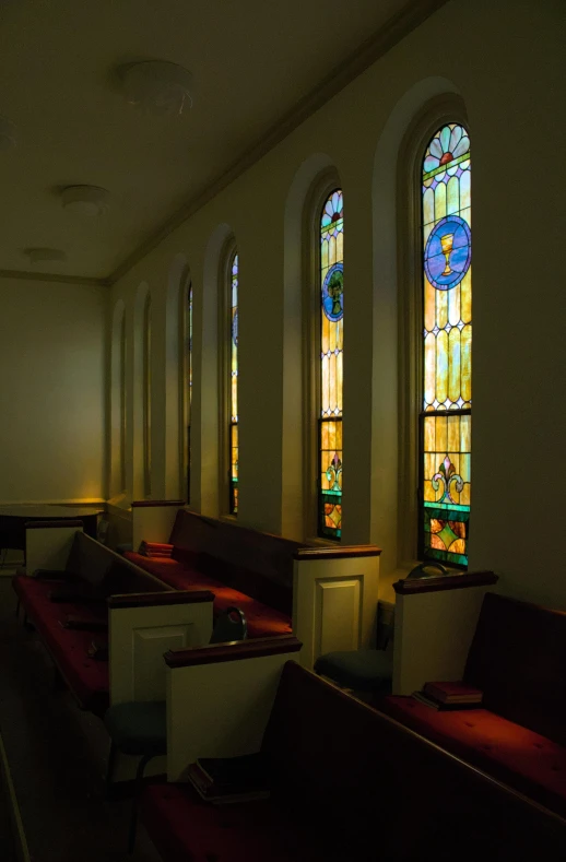 an empty church with stained glass windows in the back