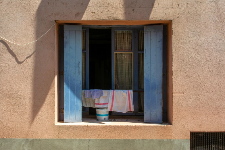 a towel and a bucket are near an open window