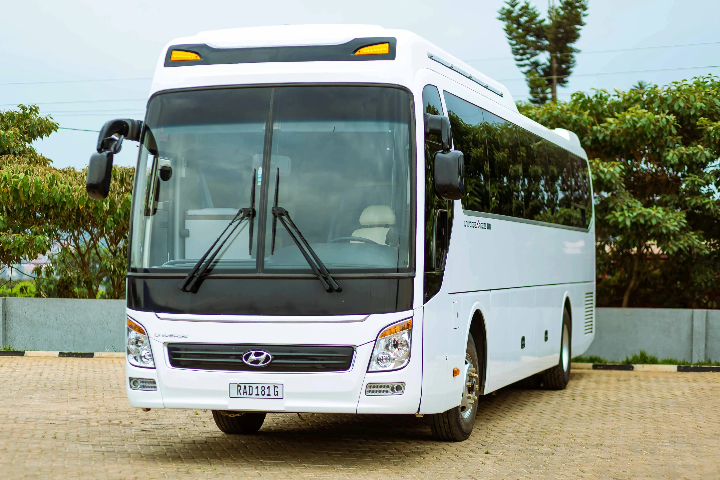 a white bus on the side of a dirt road