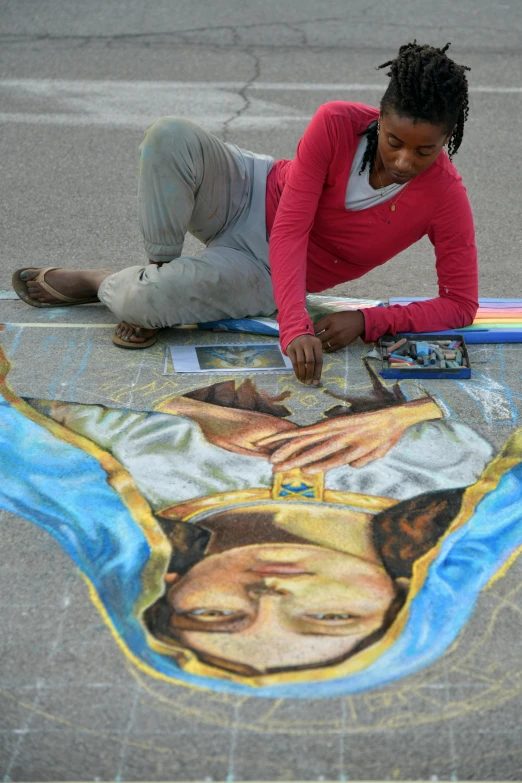 a woman on the ground using chalk paste