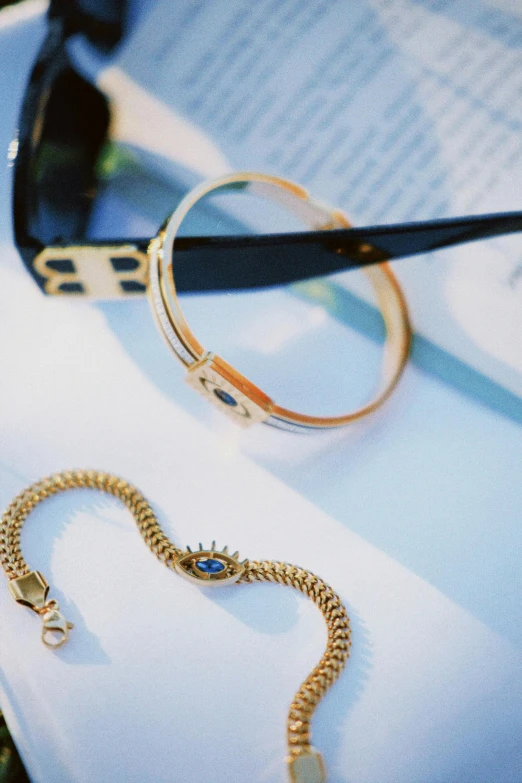 an eyeglass holder and a gold snake wrapped in chains on a folded piece of paper