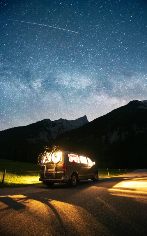 a van parked on the road at night with the lights on