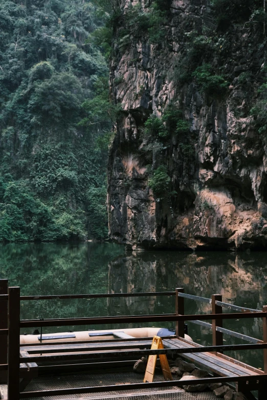 a small wooden bench sitting on the side of a lake