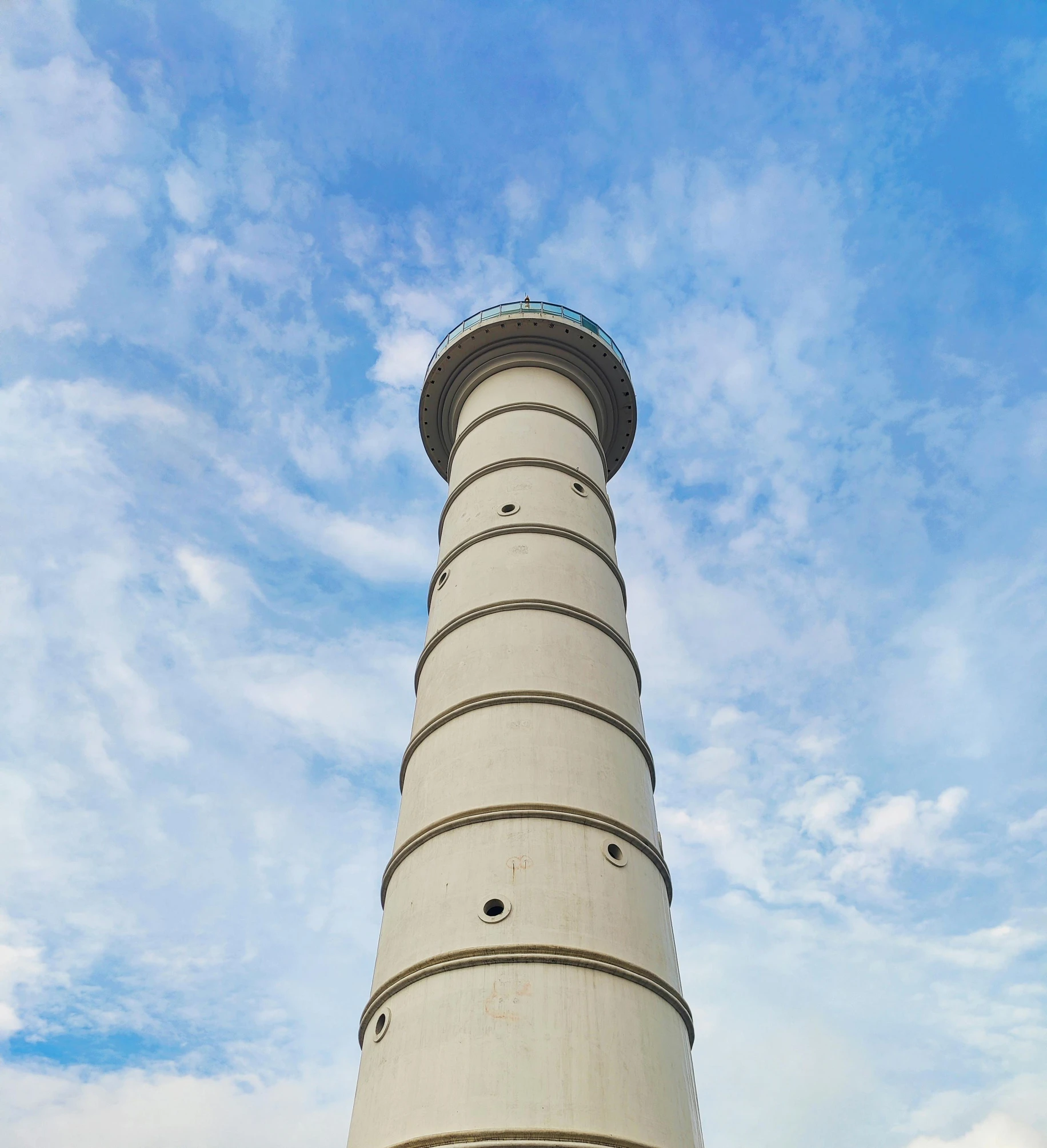 a white lighthouse with blue skies above it