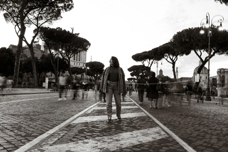 a woman is walking down the street in black and white