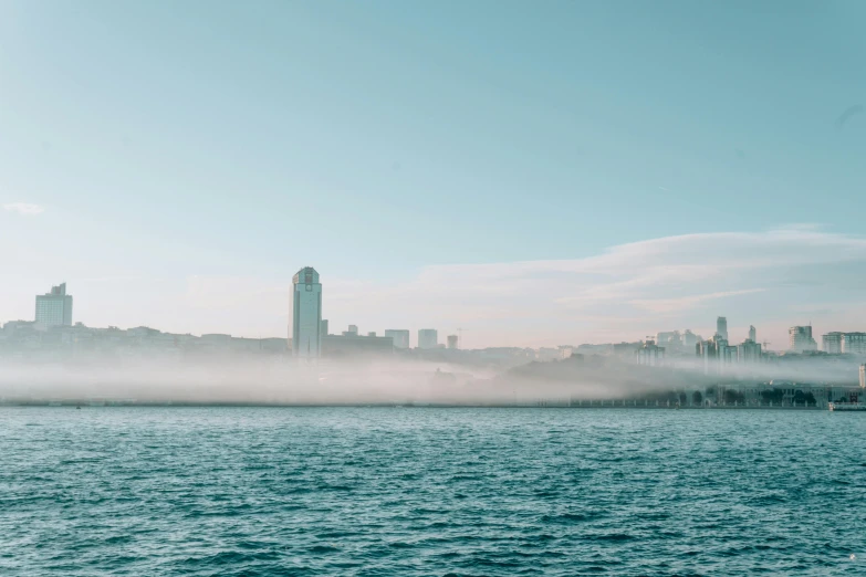 fog covers a waterway near the city skyline