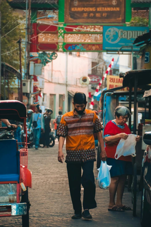 two people walking down a narrow street in an asian city