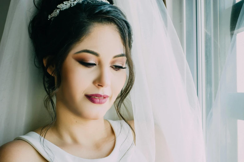 a beautiful young woman standing next to a white curtain