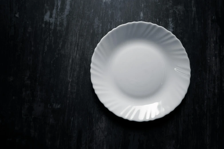 a small white plate on a black table