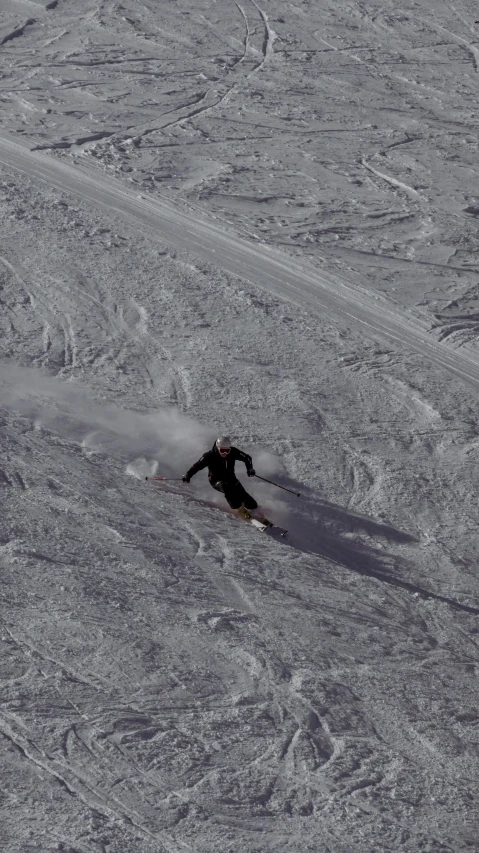 man snowboarding down a slope wearing all black