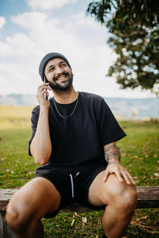 a man sitting on a bench with a cellphone to his ear