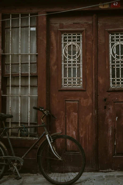 a bicycle leaning against the door of a wooden building