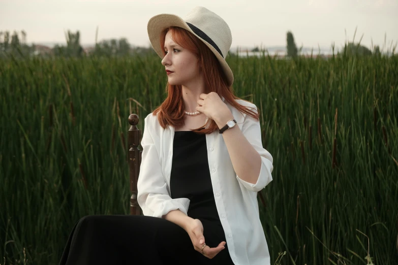 a woman in a black and white outfit, with a hat on